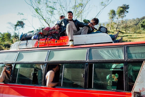 Nepalese people travelling by bus on the roof