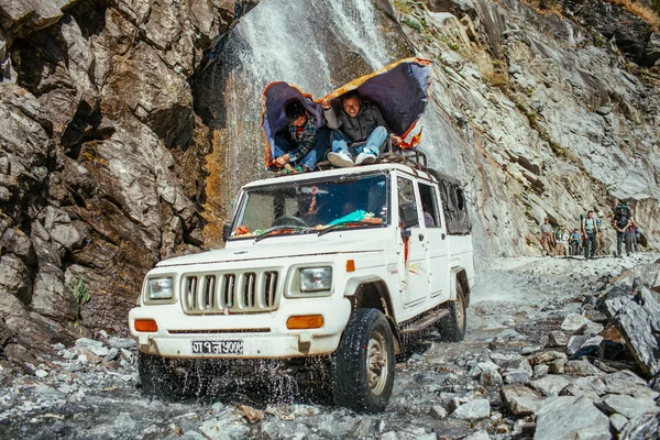 Off-road on Annapurna trekking path. People try to reach their destination, driving through the mountain stream