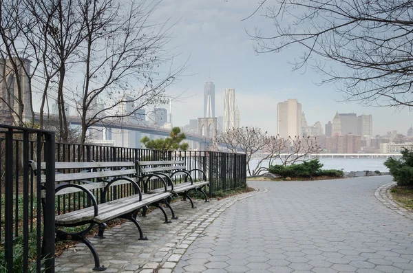 Brooklyn Bridge Park Bench and Walkway with Manhattan Skyline.