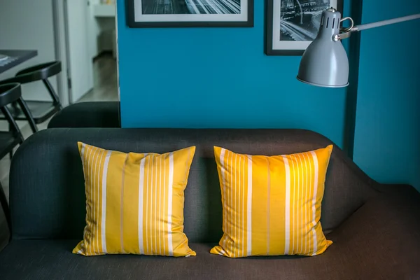 Brown sofa with yellow pillows and lamp
