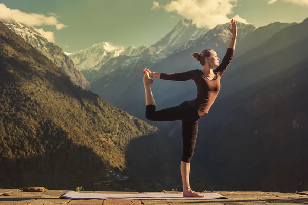 Young woman doing yoga in mountains