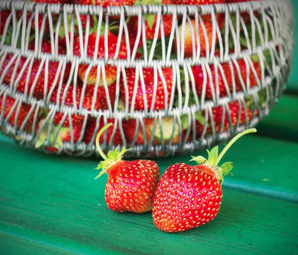 Ripe and tasty strawberries metal a basket in the street on  green bench