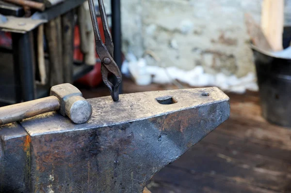 Blacksmith forges a horseshoe