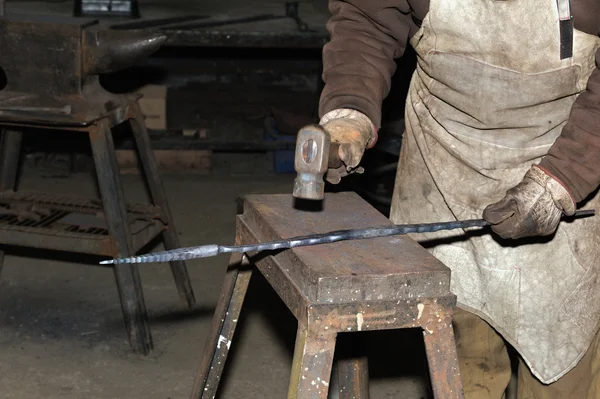 Hammering glowing steel - to strike while the iron is hot.