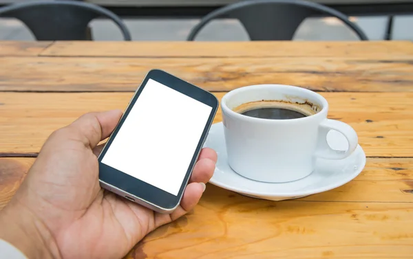 White display smart phone in hand,White coffee cup on wooden flo