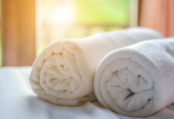 Clean white towel roll lay on the couch.