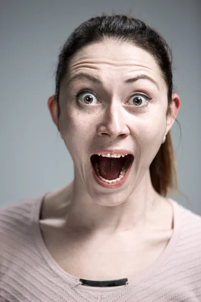 Portrait of young woman with shocked facial expression