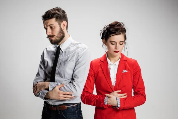 The sad business man and woman conflicting on a gray background