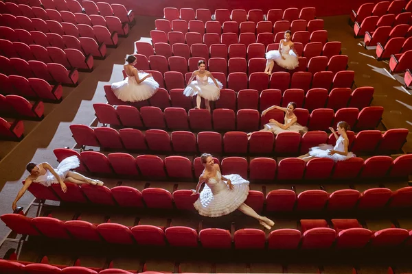 Ballerinas sitting in the empty auditorium theater