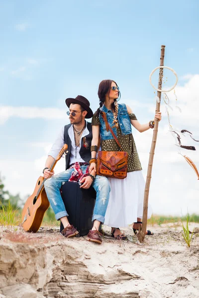 Man and woman as boho hipsters against blue sky