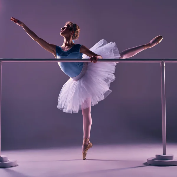 Classic ballerina posing at ballet barre