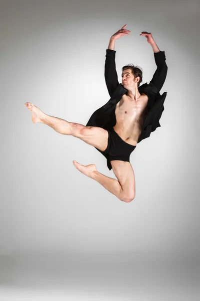 The young attractive modern ballet dancer jumping on white background
