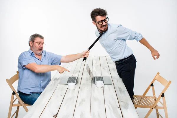 Business conflict. The two men expressing negativity while one man grabbing the necktie of her opponent