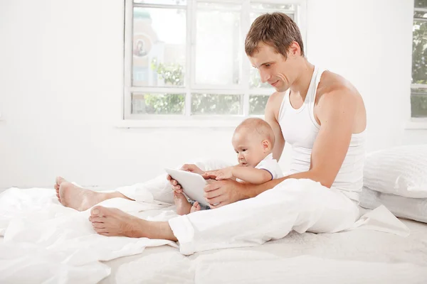 Young father and his nine months old son with digital tablet