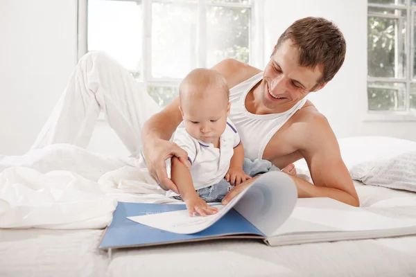 Father and baby together reading book