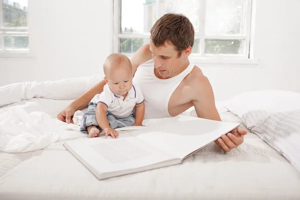 Father and baby together reading book