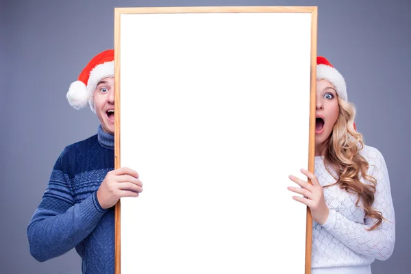 Christmas couple holding white board with empty copy space