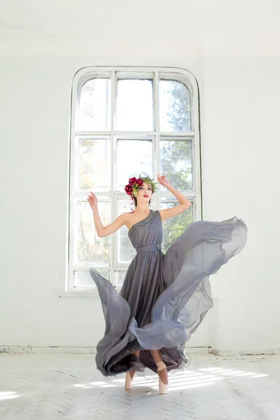 The beautiful ballerina dancing in long gray dress