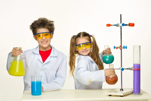 Two cute children at chemistry lesson making experiments