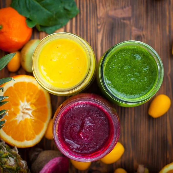 Blended green,yellow and purple smoothie with ingredients select