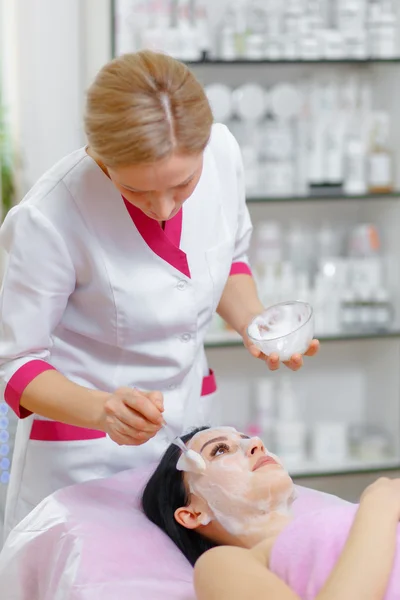 Young woman beautician is doing the cleaning procedure