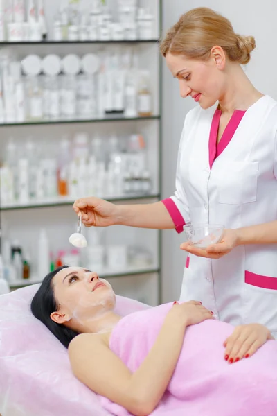 Young woman beautician is doing the cleaning procedure