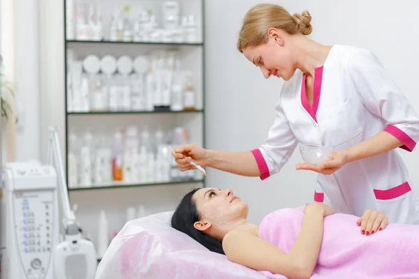 Young woman beautician is doing the cleaning procedure