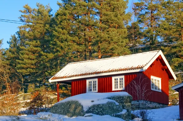 Red cottage in a beautiful snow forest