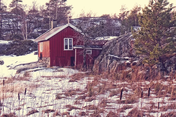 Red summer cottage among the rocks