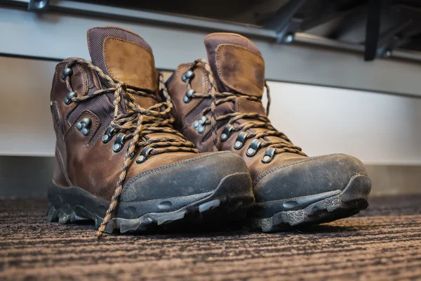 Trekking boots under the seat at the airport