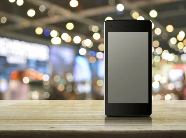 Modern smart phone with blank grey screen on wooden table in fro