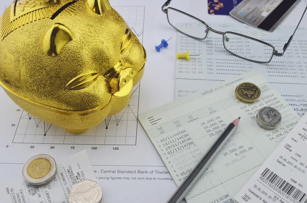 Gold piggy bank, coin and pencil on saving account book