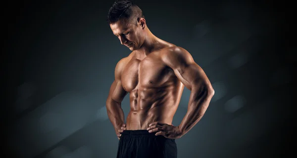 Muscular man in studio on dark background