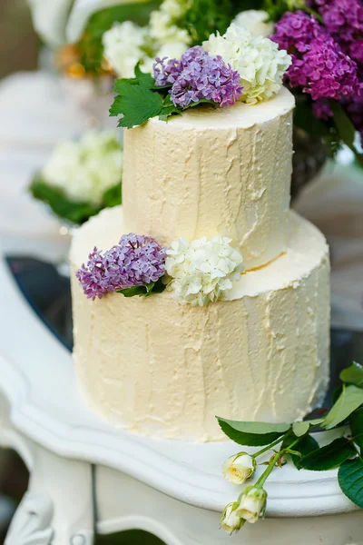 The multilevel wedding cake with lilac on the table