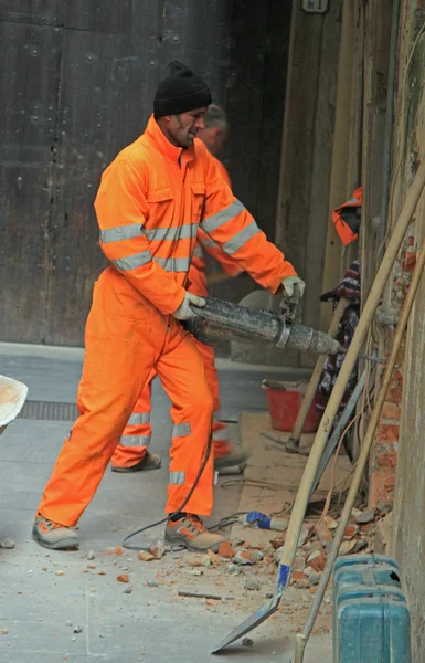 Worker is drilling wall outdoor in Padua, Italy