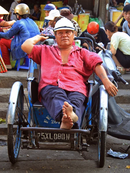 Man is sitting in a cart on street market in Hue, Vietnam