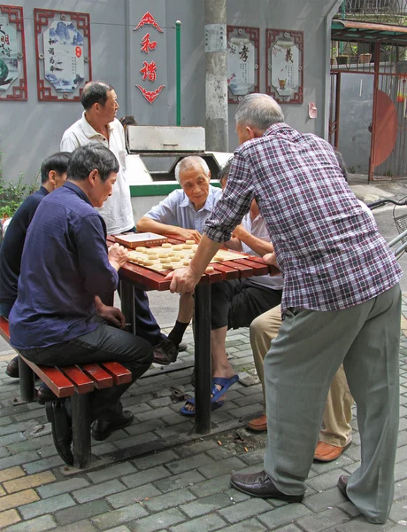 Men are playing board game outdoor in Wuhan, China