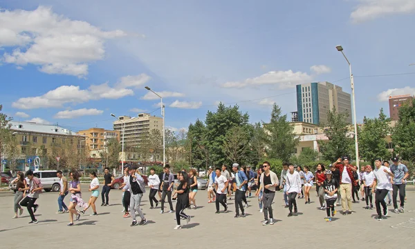Big group of people is repeating common dance on the square in Ulaanbaatar