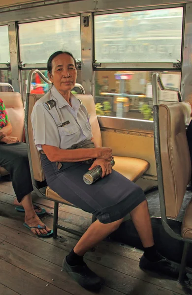 Woman-conductor in bus is sitting on a seat