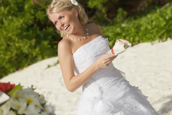 Gorgerous bride smiling, standing in front of table with piece o