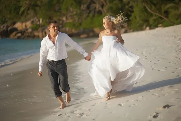 Beautiful young couple enjoying sunset, walking barefoot on beac