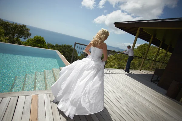 Lovely bride coming across pool area before wedding.