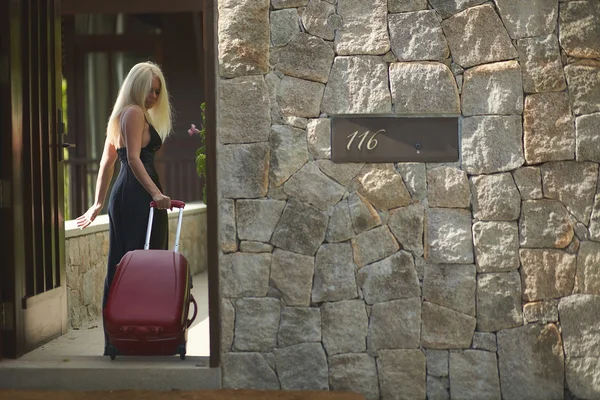 Beautiful, lovely, sexual girl walking with luggage bag to hotel