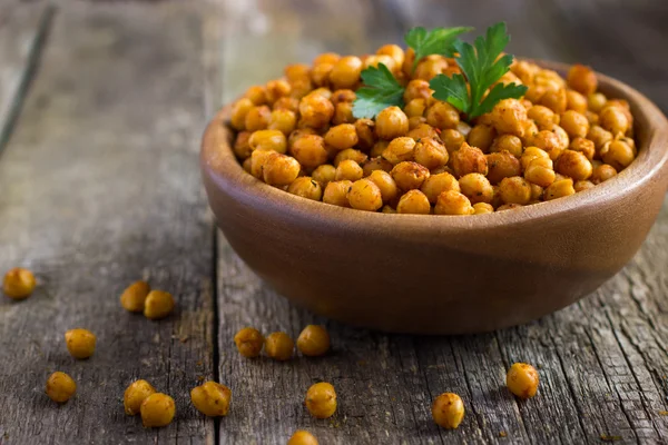 Roasted  spicy chickpeas on rustic background