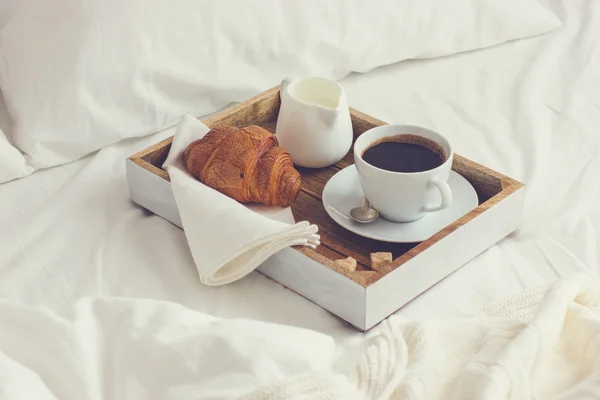 Breakfast in bad,  tray with cup of coffee and  croissant