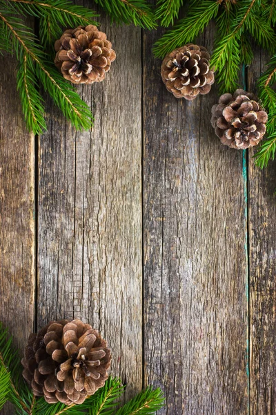 Fir branches and pine cones on wooden background