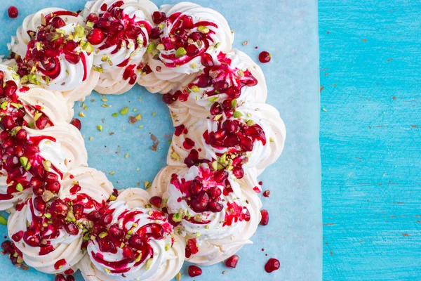 Meringues pavlova cake wreath with pomegranate, cranberry and pi