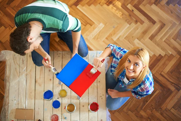 Young couple painting furniture at home