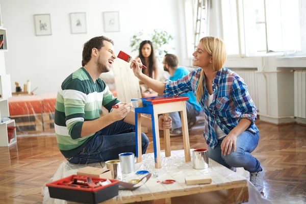 Young couple painting furniture at home