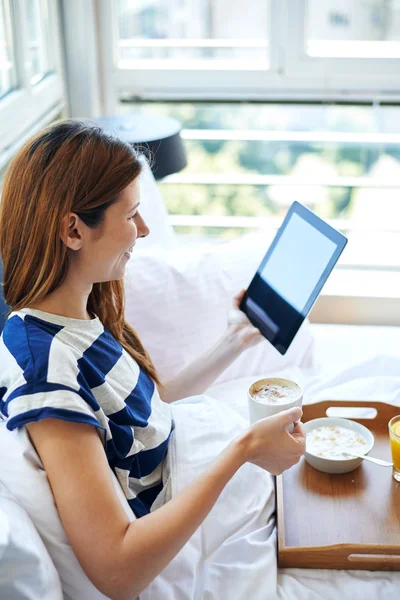 Woman in bed looking in tablet